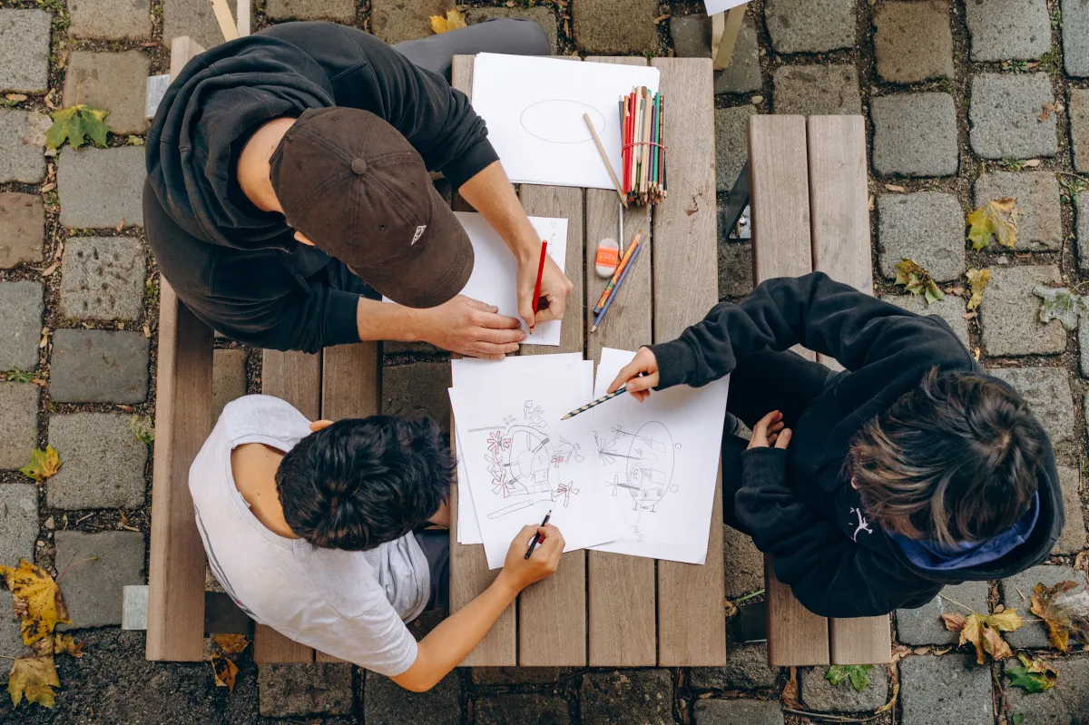 Kinder und eine Begleitperson zeichnen gemeinsam in der Kinderwerkstatt beim Zukünfte-Forum